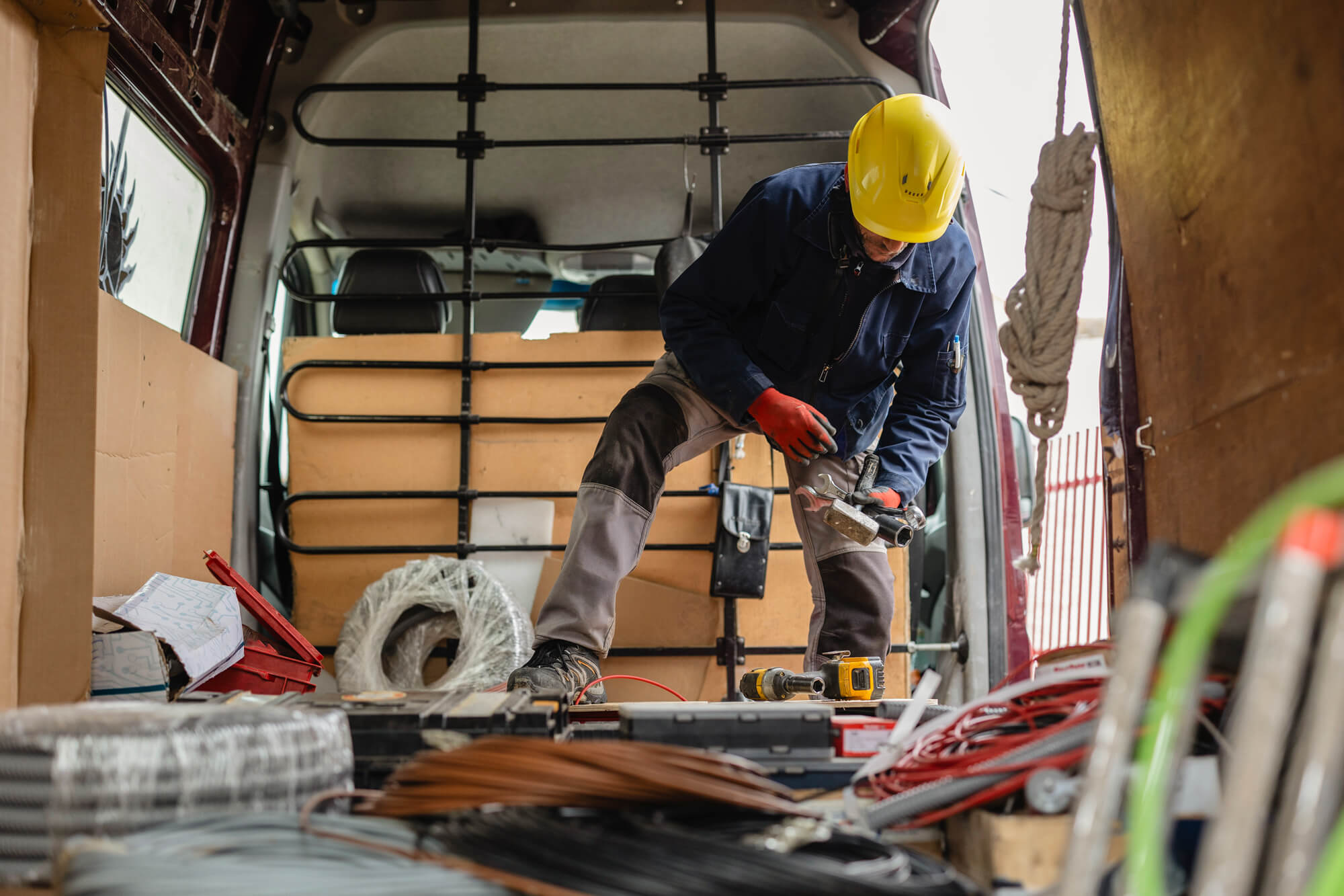 An image of an electrician preparing cables and equipment in his van